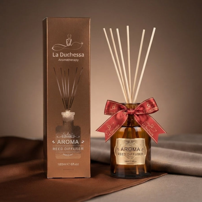 reed diffuser with a red ribbon beside its gift box